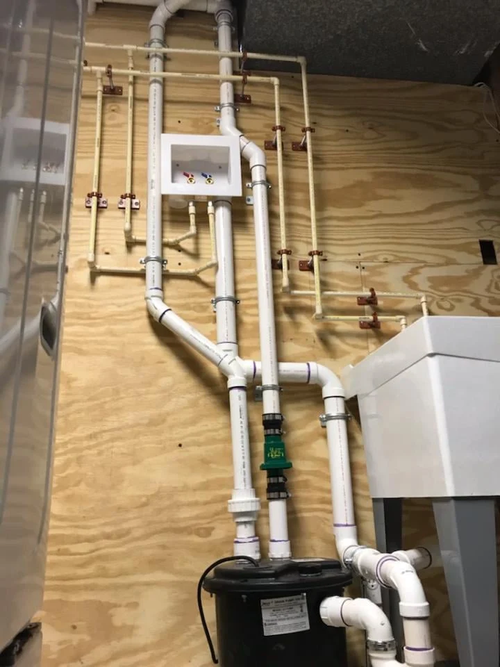Clean laundry room drain pipe and PEX supply line rough-in installation